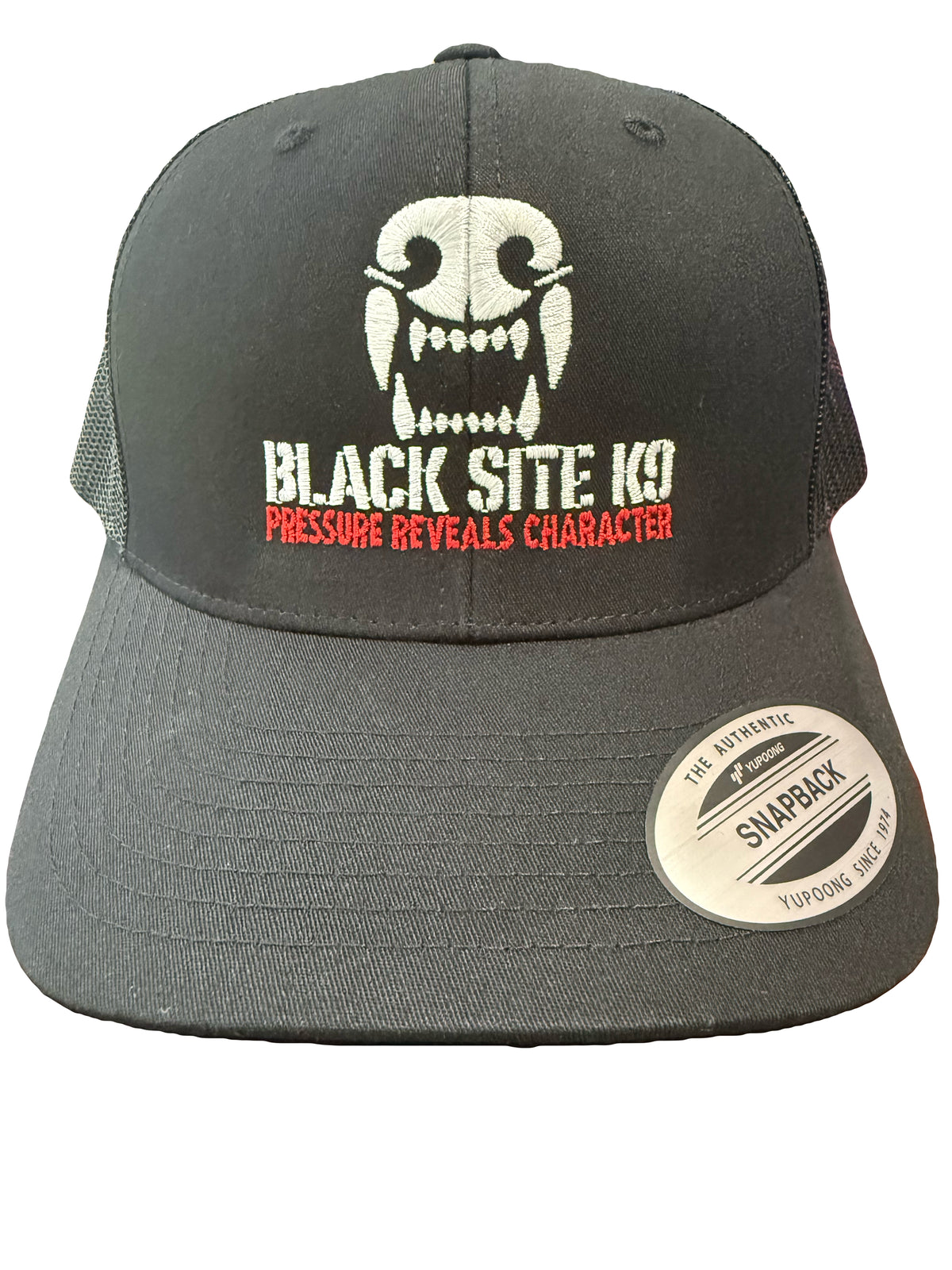 A black trucker-style snapback cap with a white embroidered skull graphic blacksitek9 logo